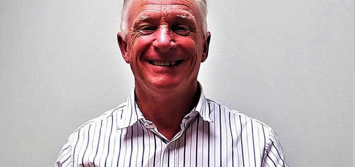 man in a stripped shirt stood in front of a grey wall